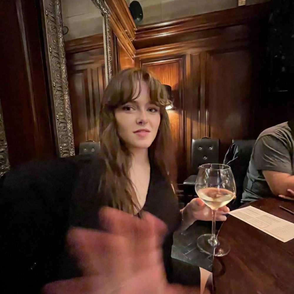 a person sitting at a table with wine glasses